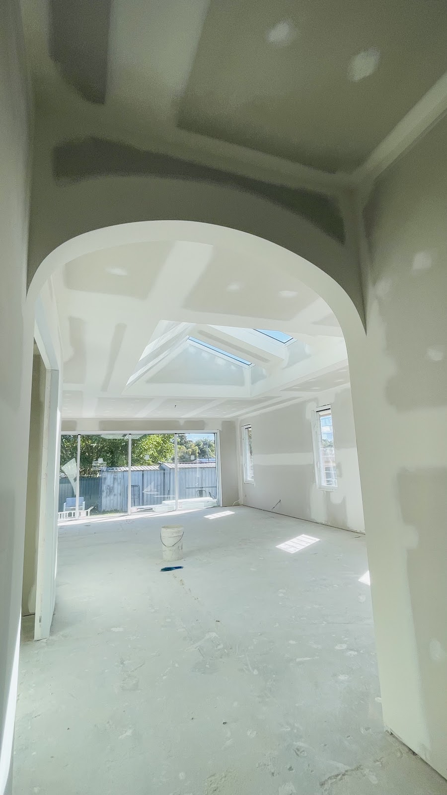 Hallway with a new arched opening, set plaster and a skylight beyond