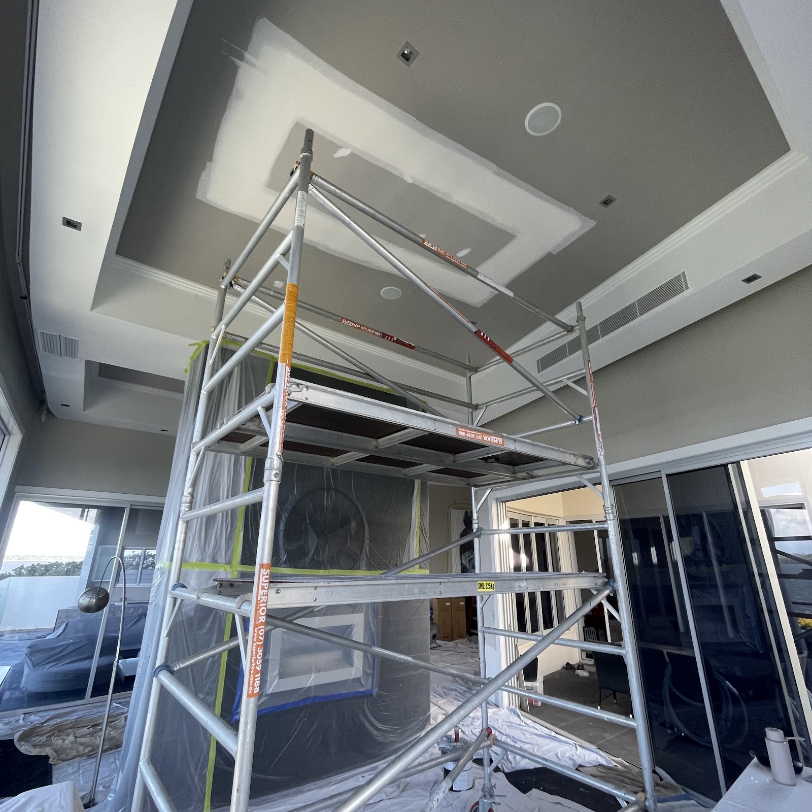 Mobile scaffold set up under a large bulkhead in a living room